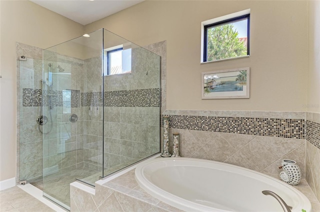 full bath featuring a garden tub, a shower stall, and tile patterned flooring