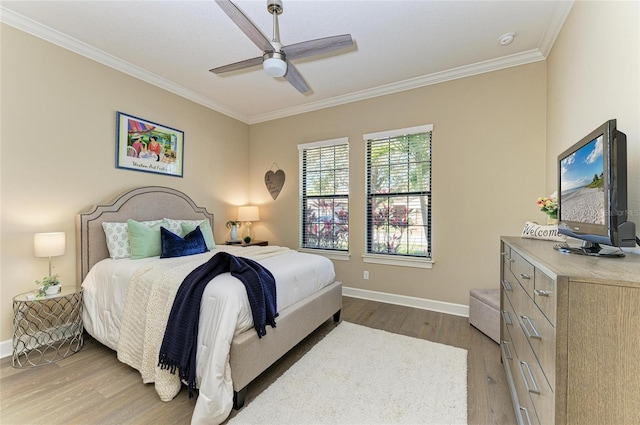 bedroom featuring ornamental molding, wood finished floors, a ceiling fan, and baseboards