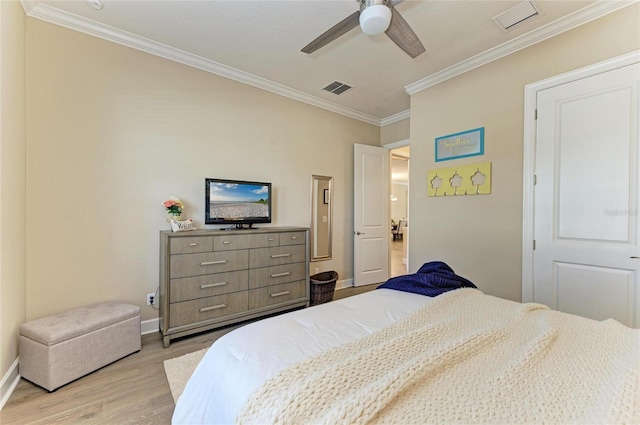 bedroom featuring light wood-type flooring, baseboards, visible vents, and ornamental molding