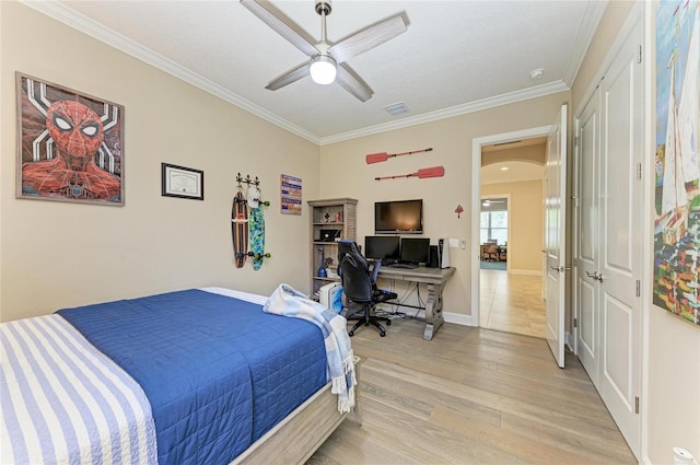 bedroom featuring visible vents, arched walkways, baseboards, light wood-style flooring, and ornamental molding