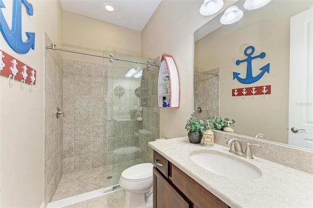 full bath featuring vanity, a tile shower, and toilet