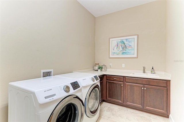 laundry area with cabinet space, a sink, and washing machine and clothes dryer