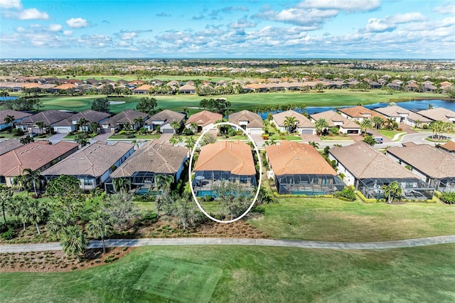 drone / aerial view with view of golf course, a water view, and a residential view