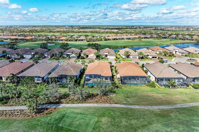 drone / aerial view featuring golf course view, a water view, and a residential view