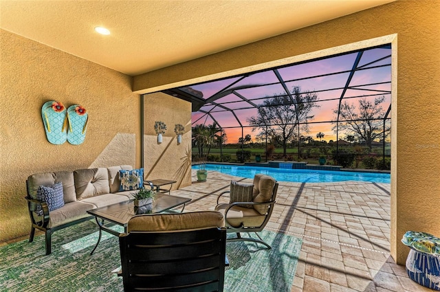 patio terrace at dusk featuring a lanai, an outdoor pool, and outdoor lounge area