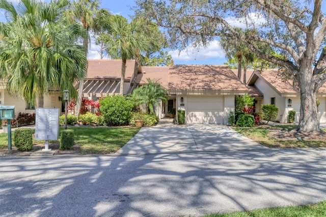 view of front of house with driveway, an attached garage, and stucco siding