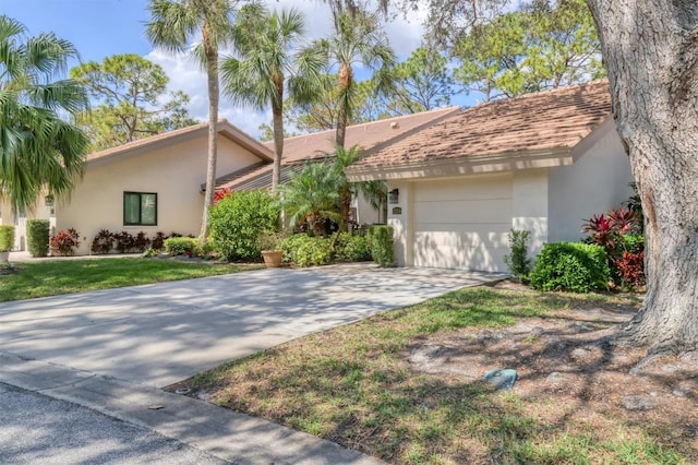 view of front of house with a garage, driveway, a front lawn, and stucco siding