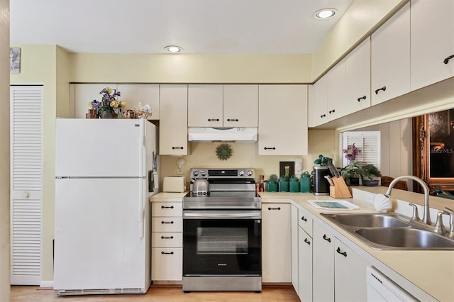 kitchen featuring under cabinet range hood, white appliances, a sink, white cabinets, and light countertops