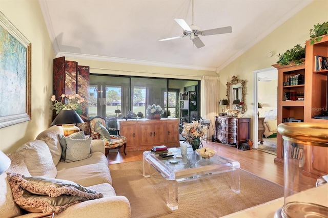 living area with vaulted ceiling, ceiling fan, ornamental molding, and wood finished floors