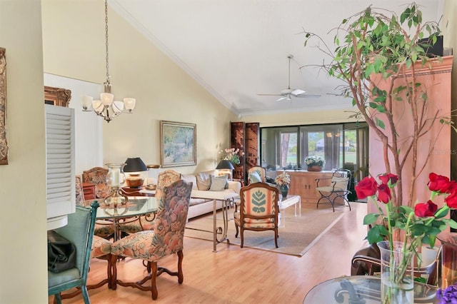 dining space featuring lofted ceiling, ceiling fan with notable chandelier, wood finished floors, and crown molding