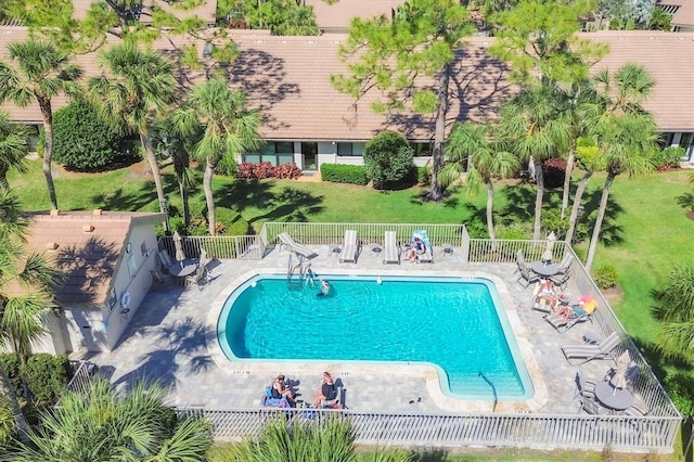 pool featuring a yard, a patio, and fence