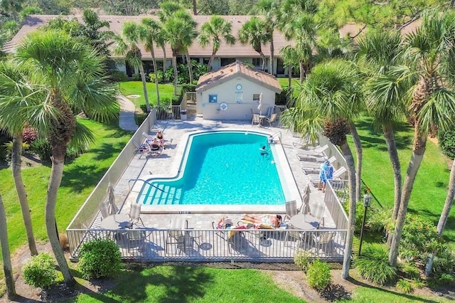 pool with a patio, a yard, and fence