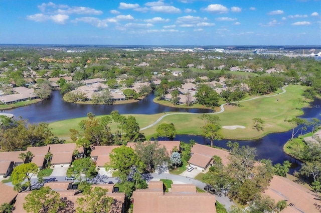 drone / aerial view featuring a residential view, view of golf course, and a water view