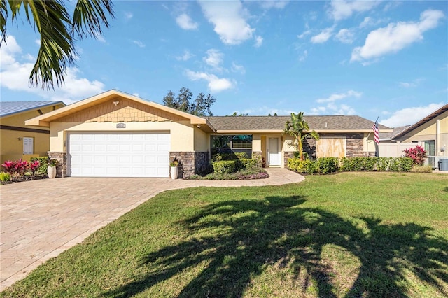 ranch-style home with a garage, stone siding, decorative driveway, a front yard, and stucco siding