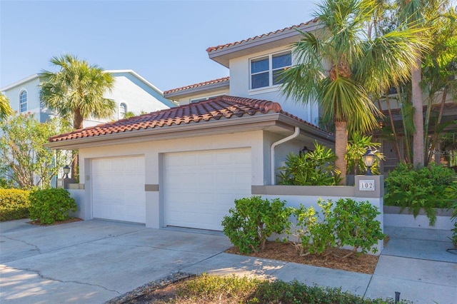 mediterranean / spanish home with driveway, a tiled roof, and stucco siding