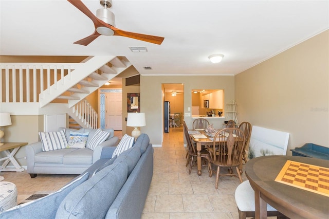 living room with crown molding, stairs, visible vents, and a ceiling fan