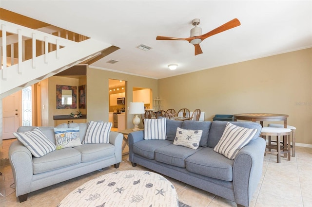 living room with visible vents, baseboards, ceiling fan, ornamental molding, and light tile patterned flooring