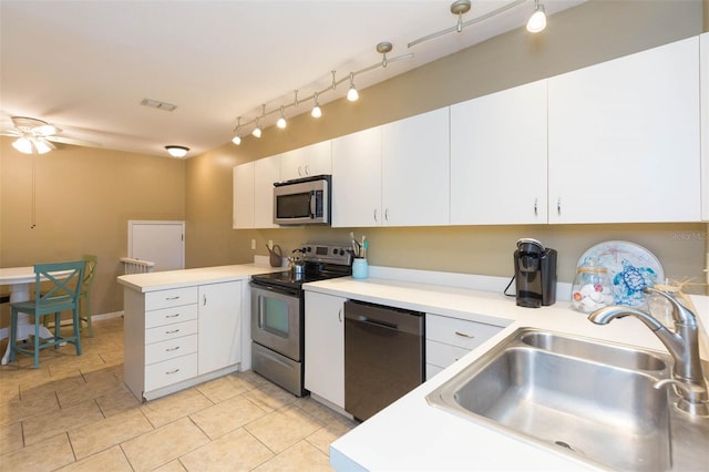 kitchen featuring stainless steel appliances, a peninsula, a sink, visible vents, and light countertops