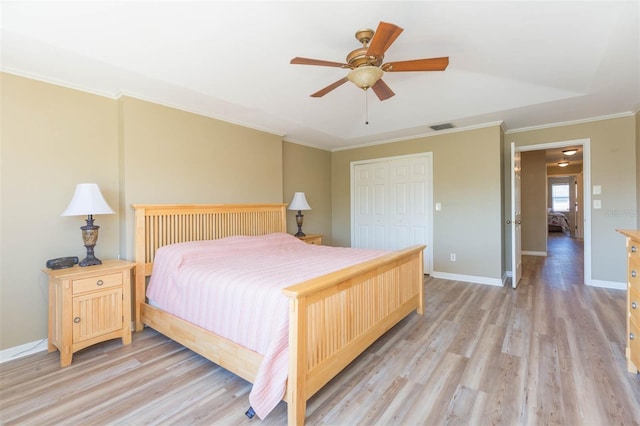 bedroom featuring baseboards, visible vents, ornamental molding, light wood-type flooring, and a closet