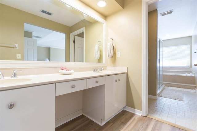 bathroom with a stall shower, visible vents, and a sink