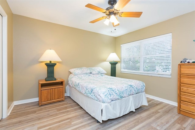 bedroom with a ceiling fan, light wood-type flooring, and baseboards