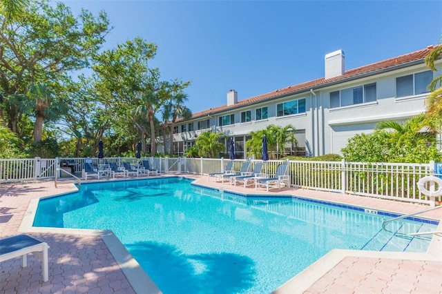 community pool featuring fence and a patio