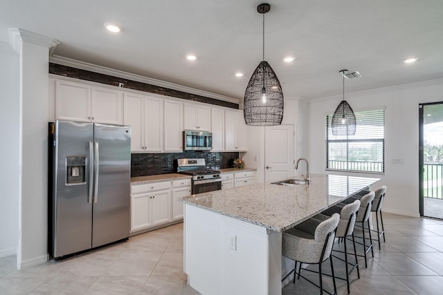 kitchen featuring a center island with sink, appliances with stainless steel finishes, white cabinets, and a sink