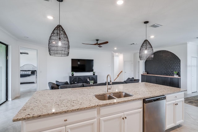 kitchen featuring ornamental molding, open floor plan, white cabinets, a sink, and dishwasher