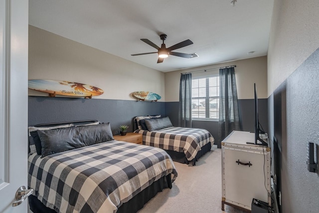 bedroom featuring a textured wall, carpet flooring, and ceiling fan