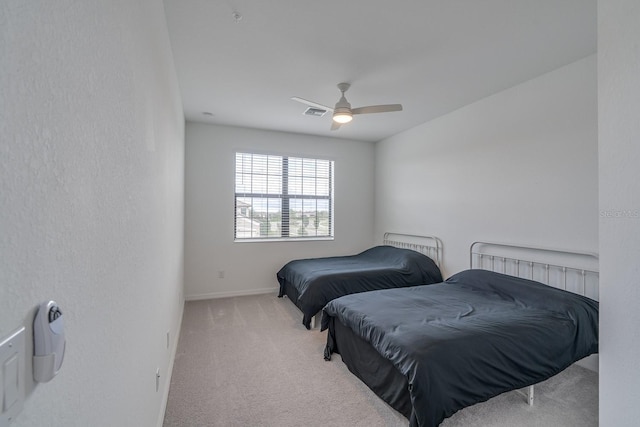 bedroom with light carpet, ceiling fan, visible vents, and baseboards