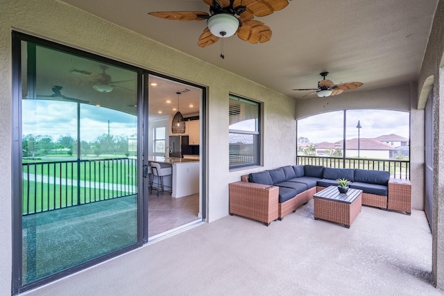 sunroom with ceiling fan and a sink