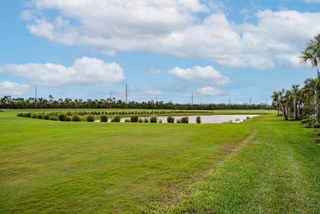 view of property's community with a rural view, a water view, and a lawn