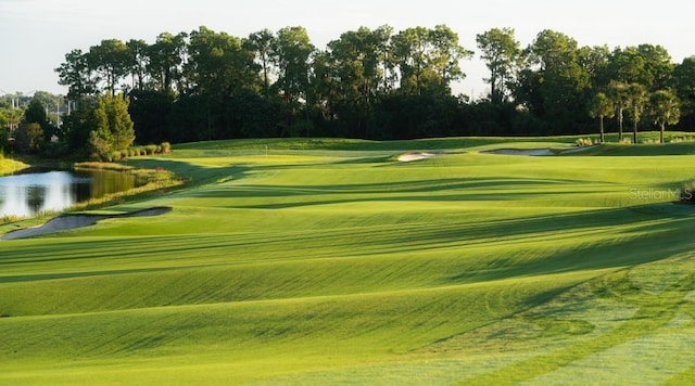 view of home's community with golf course view and a lawn