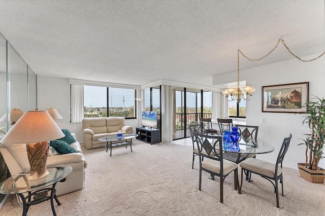 dining room featuring carpet floors, a healthy amount of sunlight, a notable chandelier, and a textured ceiling