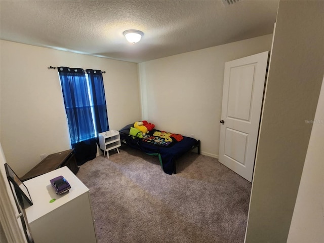 bedroom with a textured ceiling and carpet floors