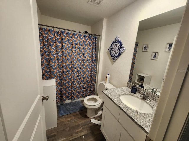 full bath featuring visible vents, a shower with shower curtain, toilet, vanity, and wood finished floors