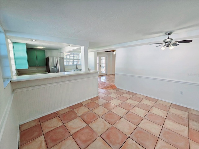 spare room featuring a ceiling fan, french doors, light tile patterned flooring, and a textured ceiling