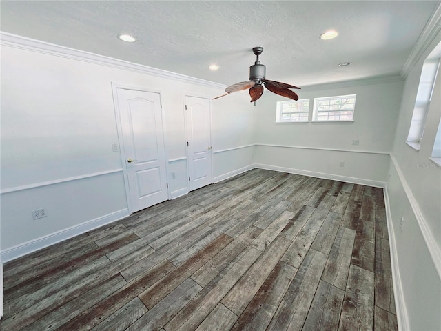 spare room with a ceiling fan, dark wood-style flooring, crown molding, and baseboards