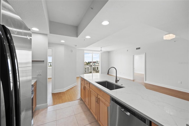 kitchen featuring visible vents, light stone countertops, stainless steel appliances, a sink, and recessed lighting