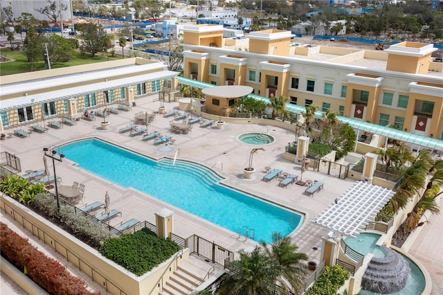 pool with a patio area, fence, and a hot tub