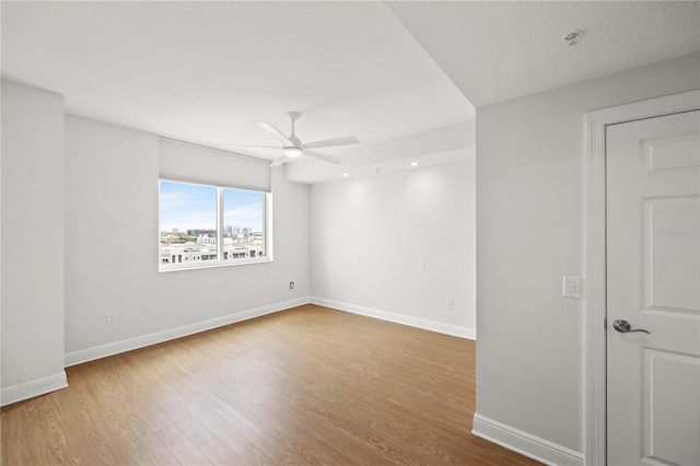 empty room with light wood-type flooring, ceiling fan, and baseboards