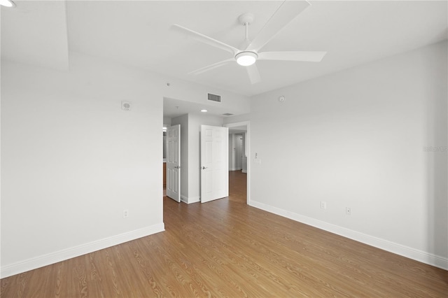 unfurnished room with baseboards, visible vents, ceiling fan, and wood finished floors