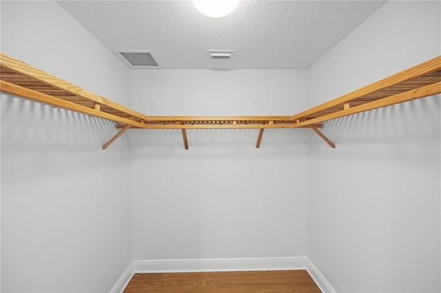 spacious closet with wood finished floors and visible vents