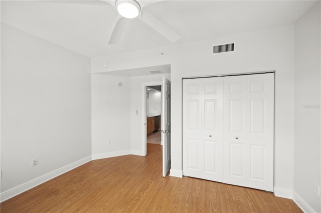 unfurnished bedroom featuring a closet, visible vents, baseboards, and wood finished floors