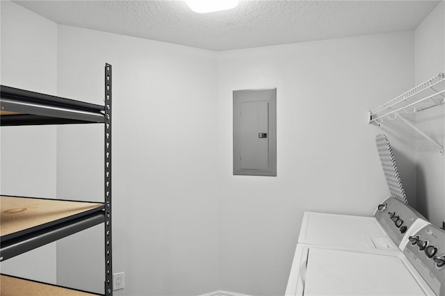 laundry room featuring a textured ceiling, separate washer and dryer, and electric panel