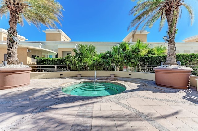 view of swimming pool with a patio, fence, and a hot tub