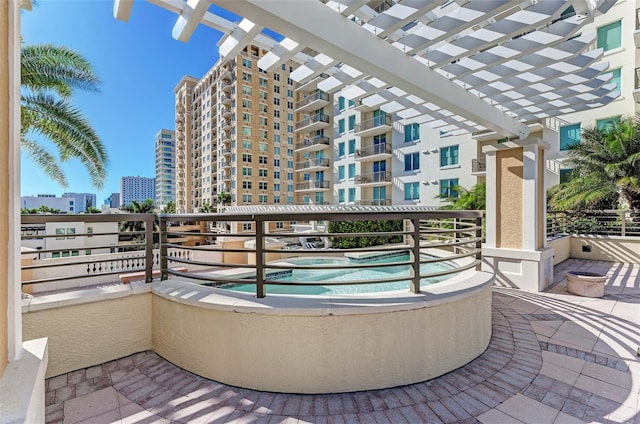 view of patio / terrace featuring a city view, a balcony, and a pergola