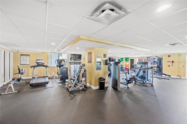 workout area featuring a drop ceiling and baseboards