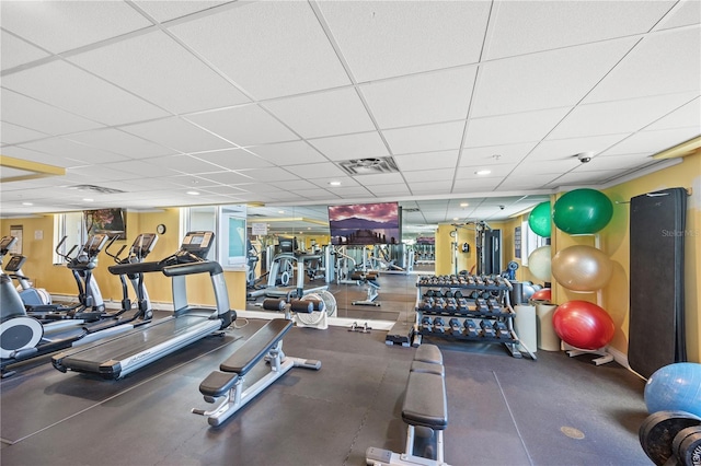 workout area featuring a paneled ceiling, baseboards, and visible vents