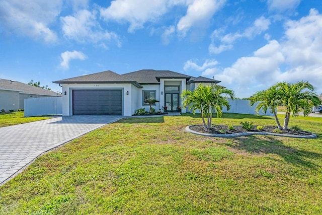 view of front of house featuring a front lawn, decorative driveway, and an attached garage